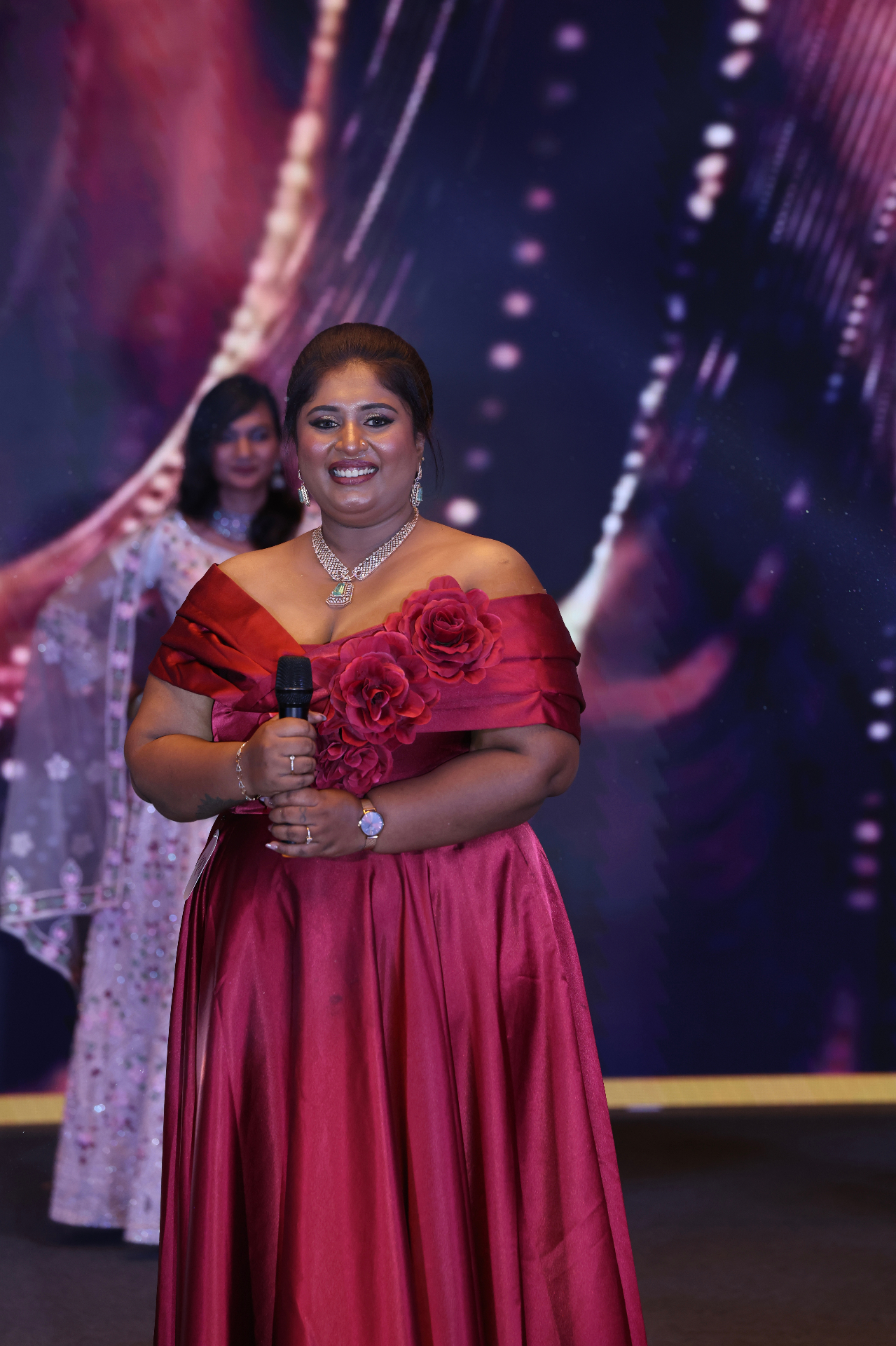 Dr. Ashvini Sundararaju addressing an audience with a microphone